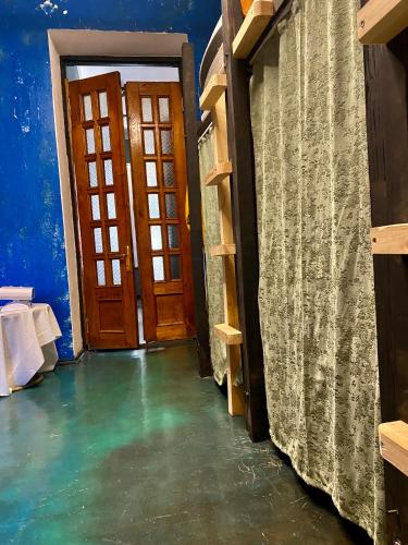 a hallway with a door and a room with blue walls at Communication hostel in Batumi