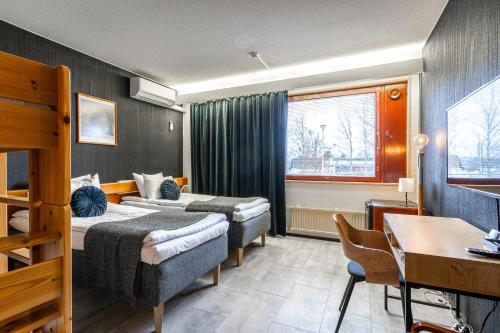 una camera d'albergo con 2 letti e una scrivania di Hotelli Jämsä a Jämsä