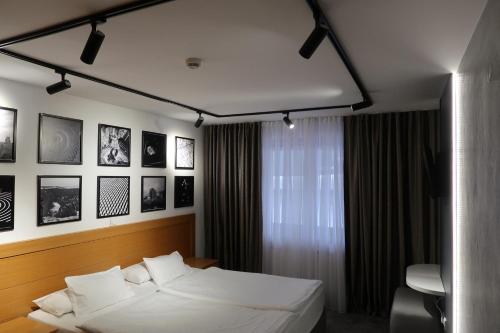 a bedroom with a white bed and some pictures on the wall at Apartman 105 Vucko Jahorina in Jahorina