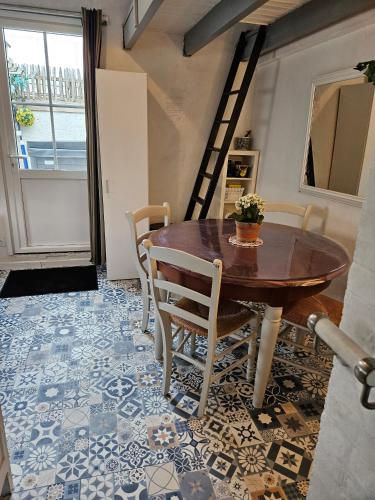 a dining room with a table and chairs and a staircase at La Maison du pêcheur - Jacuzzi 3 Etoiles in Jard-sur-Mer