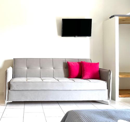 ein Wohnzimmer mit einem Sofa und rosa Kissen in der Unterkunft Harma Corfu in Sidari