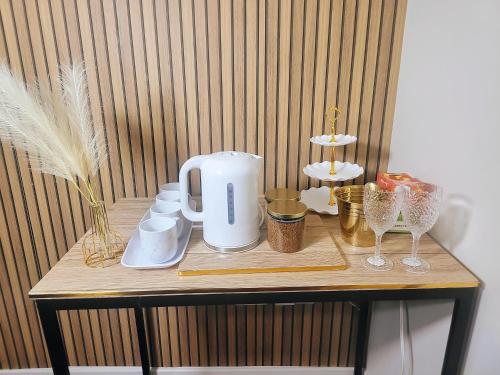 a table with a coffee maker and other items on it at Jesse 2 Bedroom Apartment by GET in Dunstable