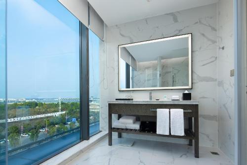 a bathroom with a mirror and a large window at Hyatt Place Changsha Airport in Changsha