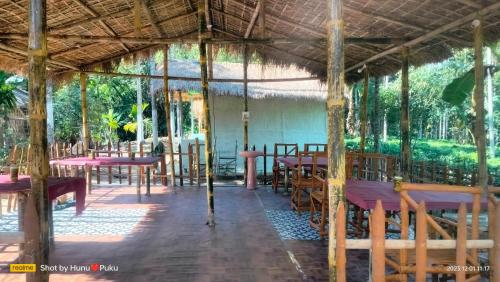 a pavilion at a restaurant with tables and chairs at Tranquil Bambusic Bliss in Kāziranga