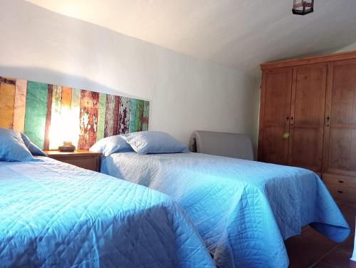 a bedroom with two beds and a wooden cabinet at Villa Aguacate in Nerja