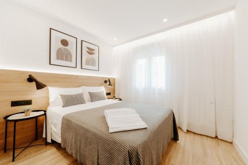 a white bedroom with a large bed and a window at Apartamento Plaza Logroño y Aire Acondicionado in Logroño