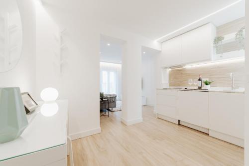 Il comprend une cuisine blanche avec des placards blancs et du parquet. dans l'établissement Apartamento Plaza Logroño y Aire Acondicionado, à Logroño