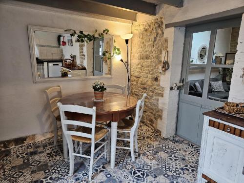a table and chairs in a room with a kitchen at La Maison du pêcheur - Jacuzzi 3 Etoiles in Jard-sur-Mer