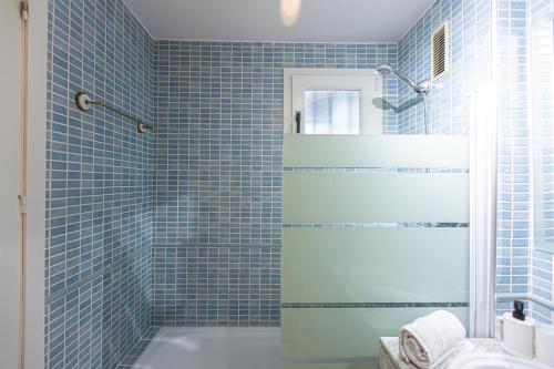 a blue tiled bathroom with a tub and a shower at LUZ in Sierra Nevada