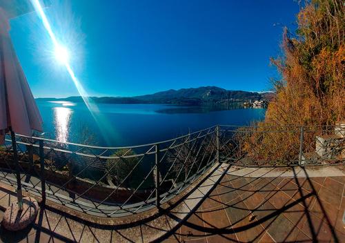 een uitzicht op een meer met de zon bij Lake view rooms and flats Casa Sul Lago in Orta San Giulio