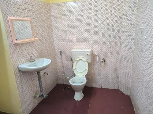 a bathroom with a toilet and a sink at LA villa Rani in Madurai