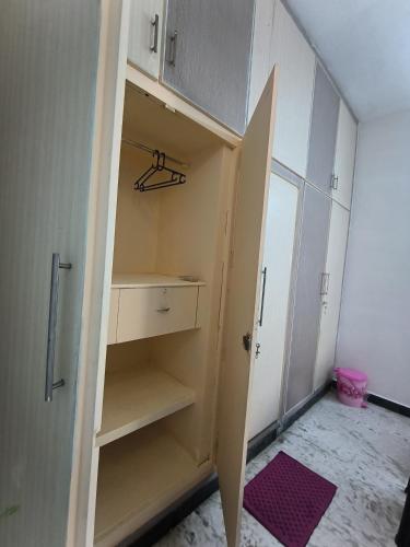 a room with a closet with white cabinets at LA villa Rani in Madurai