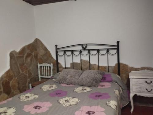 a bedroom with a bed with a floral bedspread at CASA BACO in Casas Ibáñez