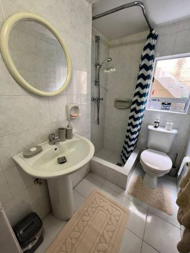 łazienka z umywalką, toaletą i lustrem w obiekcie Graswald, 1 bedroom accommodation w Gżirze