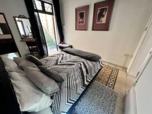 ein Schlafzimmer mit einem Bett mit Kissen und einem Fenster in der Unterkunft Graswald, 1 bedroom accommodation in Gżira