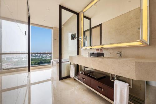 a bathroom with a sink and a large window at Sheraton Changde Wuling Hotel in Changde