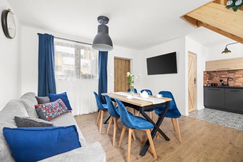 a living room with a table and blue chairs at Siedlisko Złota Góra domki całoroczne na Kaszubach in Brodnica