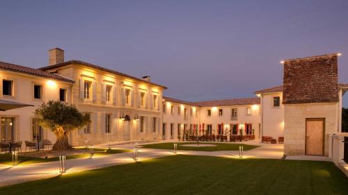 a large building with a lawn in front of it at Château Fage La Maison des Vignes - Saint-Émilion in Arveyres