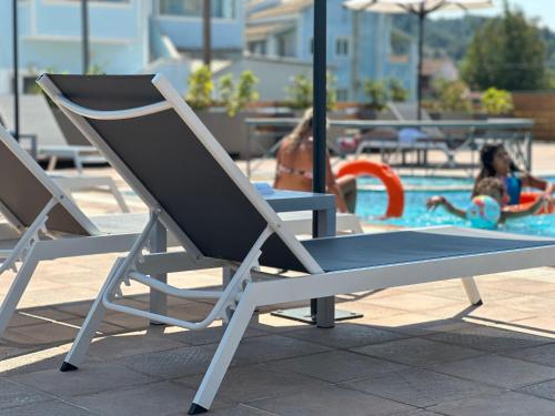 a pair of chairs sitting next to a swimming pool at Harma Corfu in Sidari
