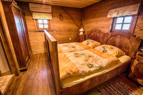 - une chambre avec un lit dans une cabane en bois dans l'établissement Vineyard Cottage Skatlar, à Otočec