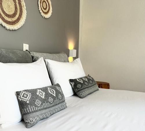 a bedroom with a white bed with two pillows at Harma Corfu in Sidari