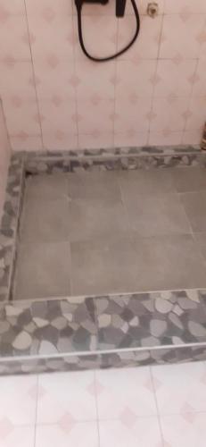 a bathroom with a tiled floor and a hose at Villa Bella is 5 mins from the beach with amazing garden overlooking the pool in Trou dʼ Eau Douce