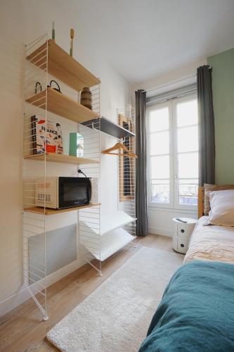 - une chambre avec un lit et une étagère avec un four micro-ondes dans l'établissement Studio design 2 personnes, à Toulouse