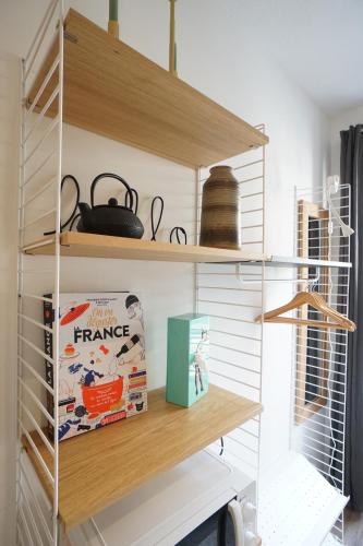 une étagère avec des livres et une boîte sur elle dans l'établissement Studio design 2 personnes, à Toulouse