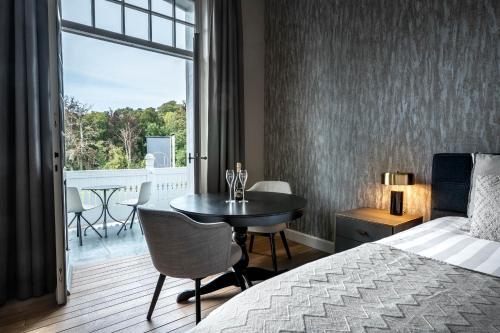 a bedroom with a bed and a table and a balcony at Landgoed Altenbroek in Voeren