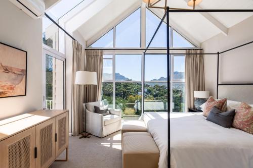 a bedroom with a bed and a large window at Elite Retreats -Forest Villa C, back up power for load shedding in Cape Town
