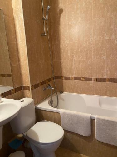 une salle de bains avec toilettes, baignoire et lavabo dans l'établissement Neon Gondola apartment, à Bansko