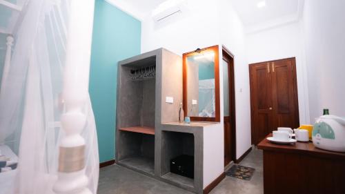 a bathroom with a sink and a mirror at Daffodil Restaurant & Holiday Resort in Unawatuna