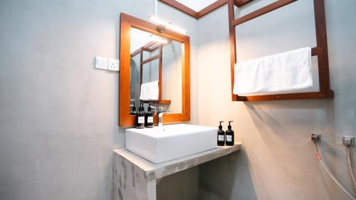 a bathroom with a white sink and a mirror at Daffodil Restaurant & Holiday Resort in Unawatuna