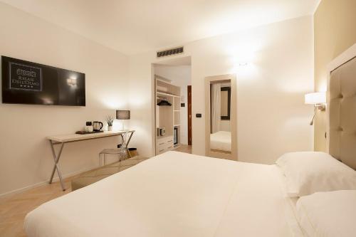 a white bedroom with a bed and a desk at Relais dell'Olmo in Perugia