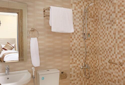 ein Bad mit einer Dusche, einem WC und einem Waschbecken in der Unterkunft La Riva Hotel in Aqaba