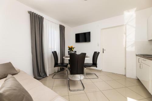 a living room with a table and black chairs at Apartments Lacrima in Šilo