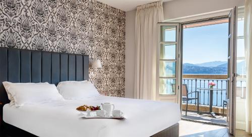 a bedroom with a bed with a breakfast on it at Park Hotel Italia in Cannero Riviera