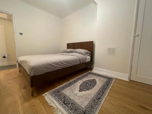 um quarto com uma cama com um tapete no chão em Homely and very comfortable apartment em Londres