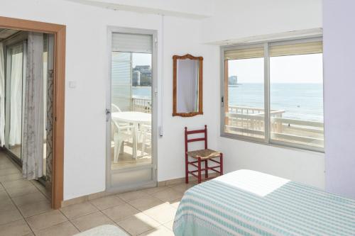 a bedroom with a bed and a view of the ocean at Santa Marta, I- A 4º-11 in Cullera