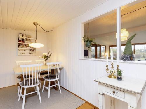 een keuken en eetkamer met een tafel en stoelen bij Holiday home Væggerløse XL in Bøtø By