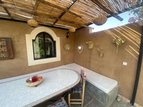 Cette chambre dispose d'une table, d'une baignoire et d'une fenêtre. dans l'établissement VILLA PISCINE MARRAKECH, à Marrakech