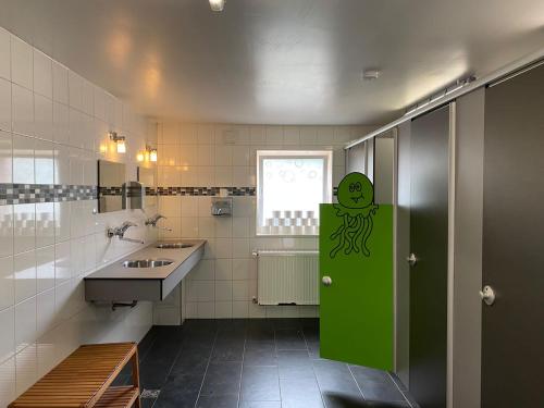 Un baño con una puerta verde con un pulpo. en Camping Braunlage, en Braunlage