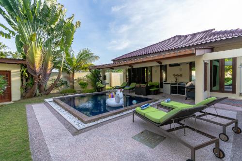 a backyard with a swimming pool and a house at The Villa - Private Pool WOW Holiday Homes in Kuah