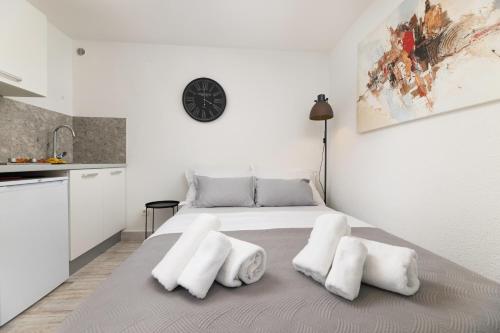 a white bedroom with a bed with two white pillows at Apartments Lacrima in Šilo