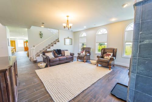 - un salon avec deux chaises et un escalier dans l'établissement Lake Vista Grand Villa - 7BR, Hot Tub, Sauna, Wi-Fi, à Kenai