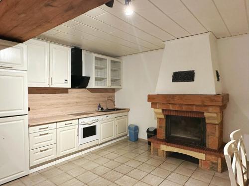 une cuisine avec des placards blancs et une cheminée dans l'établissement Zimmer in 100m² Wohnung mit Terrasse, à Duisbourg