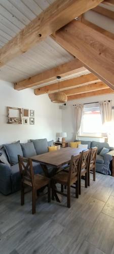 a dining room with a table and a blue couch at Smocze Ranczo 3 in Ośno Lubuskie