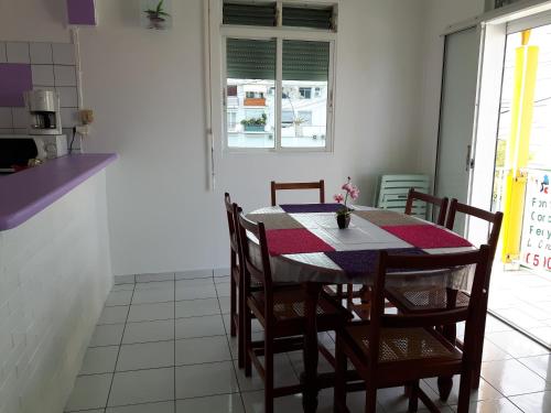 a kitchen with a table and chairs in a room at Appartements: plage & commerces à 200m in Sainte-Anne