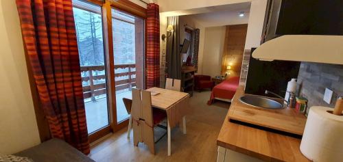 a room with a desk with a sink and a window at Super appart Risoul Alpes du Sud in Risoul