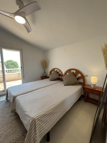 1 Schlafzimmer mit 2 Betten und einem Fenster in der Unterkunft SA CALMA - Duplex con piscina y cerca del Mar - Deltavacaciones in L'Ampolla